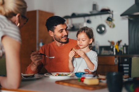 child eating a meal with parents